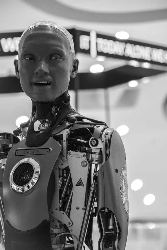 Mastering the First Impression: Your intriguing post title goes here Detailed black and white image of an advanced humanoid robot with visible mechanical parts, set indoors.